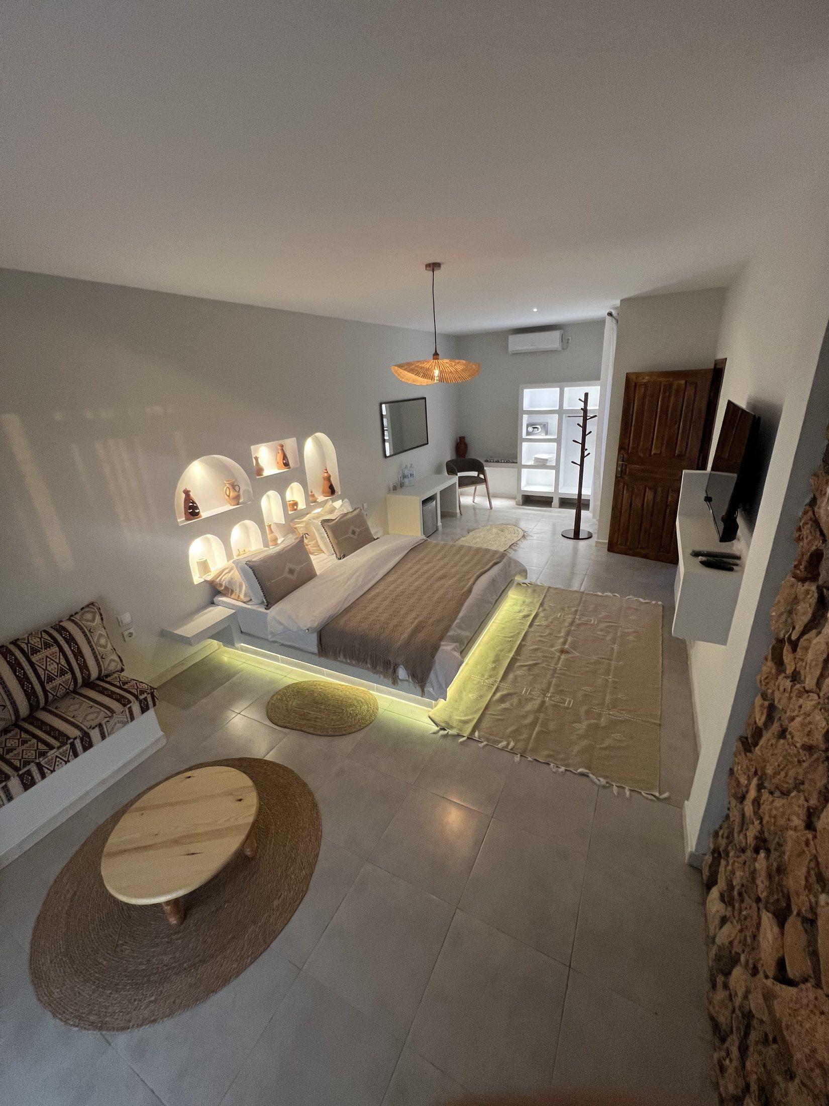 Suite Medjool — espace majlis, banquettes basses et mur en pierre